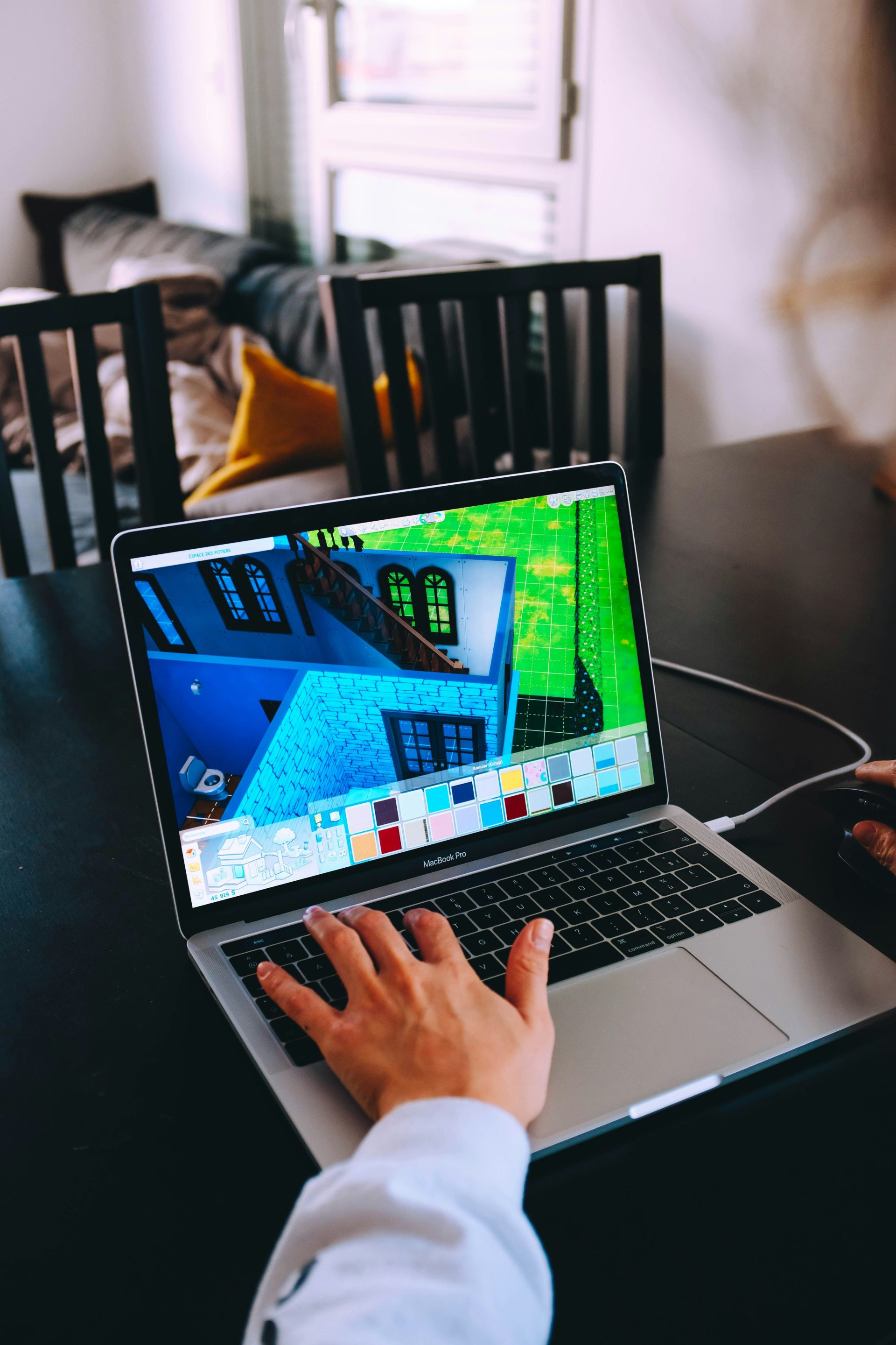 person using macbook pro on black table